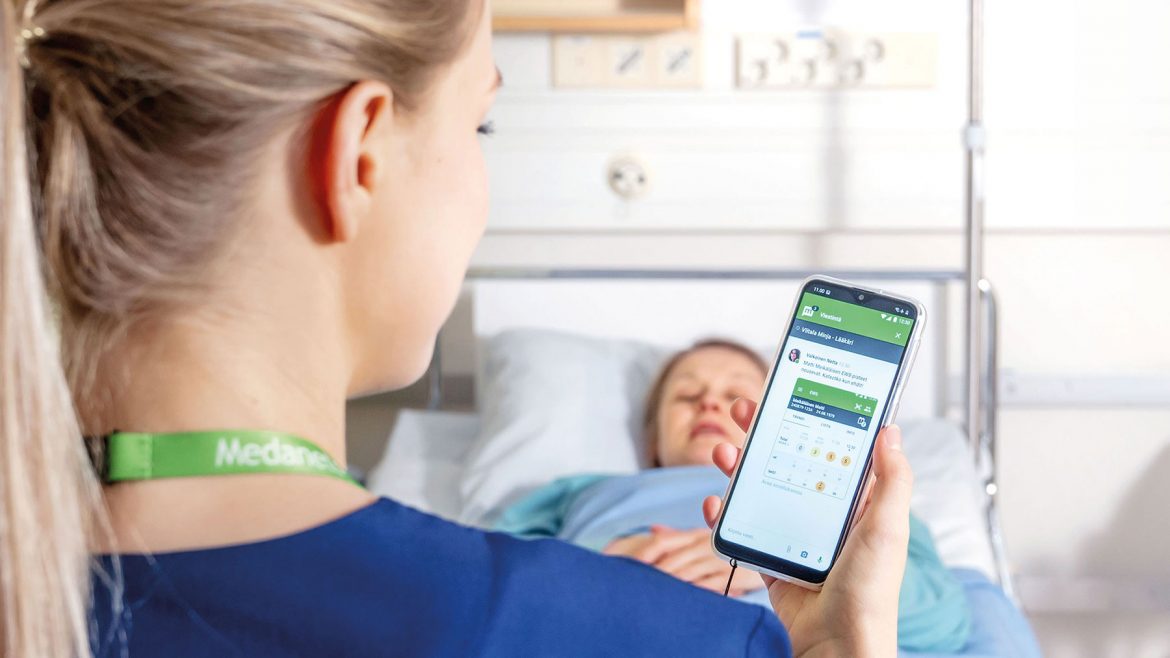 Krankenschwester nutzt Pflege-App patientennah am Krankenbett